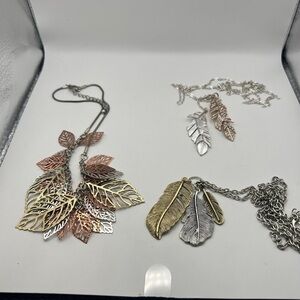 1 gold, copper, & siilver tone leaf necklace & 2 feather necklaces. Info below